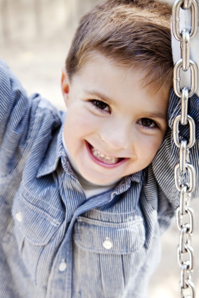 Smiling Boy on Tire Swing, Close Up