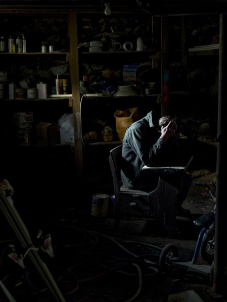Man Sitting in Dark Basement