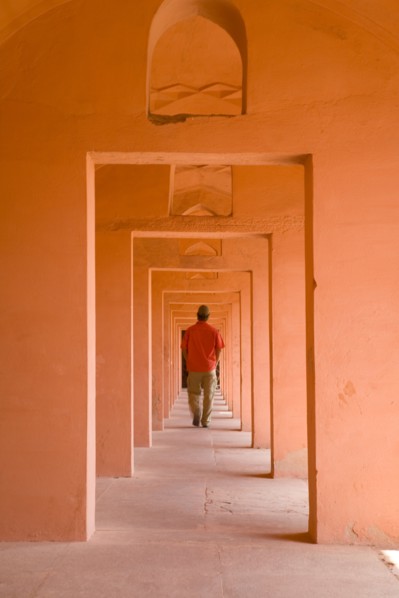 Man Walking Through Series of Orange Doorways