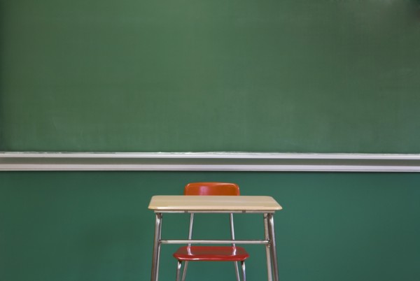 Empty Desk by Classroom Chalkboard