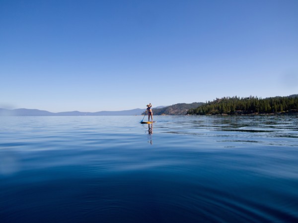 Woman Paddling on Lake in Distance
