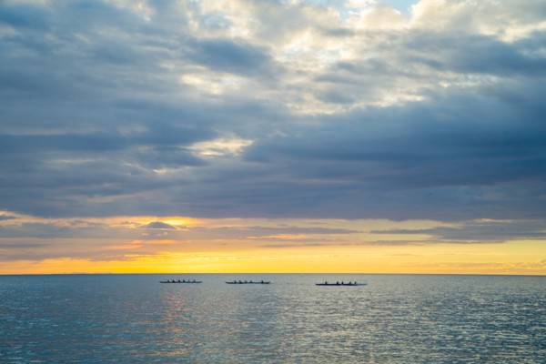 Three Outrigger Canoe Clubs Paddling at Sunset, Hawaii, USA
