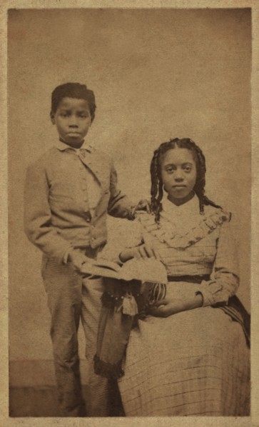 Full-length Portrait of an African American Boy Standing next to African American Girl, Seated with an Open Book, William A. Gladstone Collection of African American Photographs, late 1860's