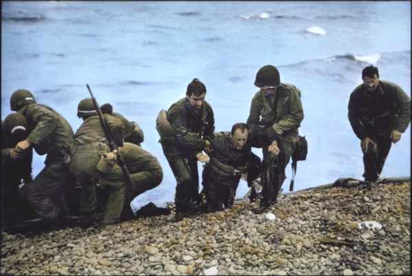U.S. Soldiers of 116th Regiment of the 29th Infantry Division being helped to shore after Arriving at Omaha Beach in Life Raft after their Landing Craft Vehicle, Personnel (LCVP) had been Sunk off Bea...