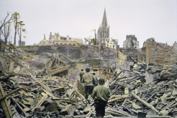 American Infantry Patrol Walking Through Ruins of the French Town, Saint-Lo, after it was Captured from the Germans, South Tower of Church of Notre Dame de Saint-Lo in Background, Battle of Normandy, ...