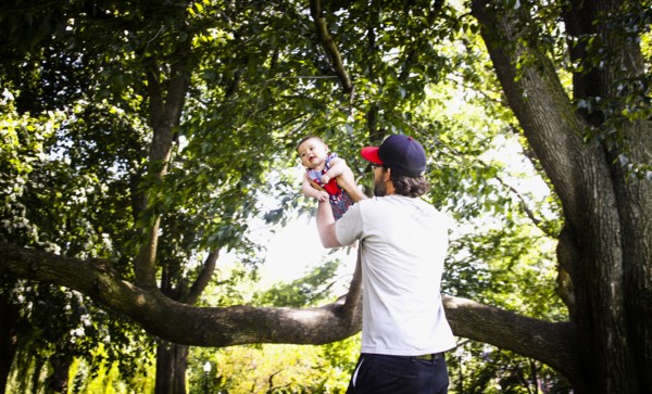Father Holding up Infant Son in Park