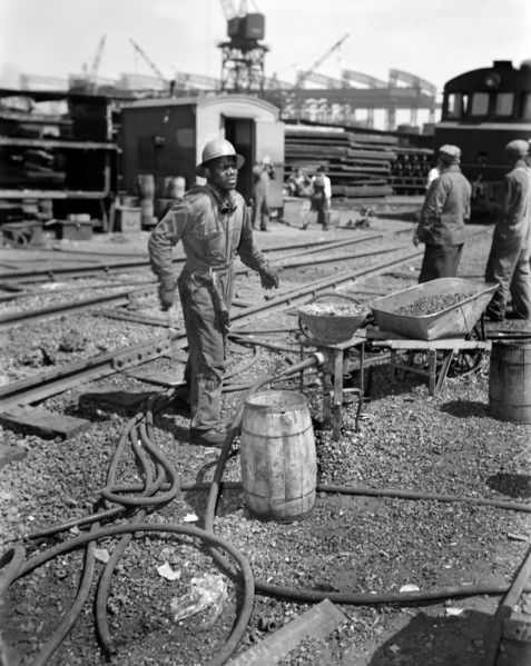 Rivet Heater engaged in Construction of Liberty Ship Frederick Douglass, Bethlehem-Fairfield Shipyards, Baltimore, Maryland, USA, Roger Smith, U.S. Office of War Information, May 1943