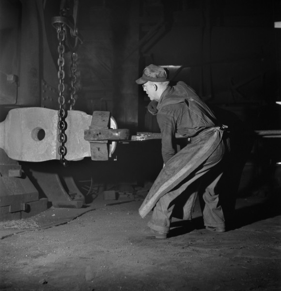 Workman manipulating a Hot Forging which is being hammered under a Steam Hammer at Blacksmith Shop of Atchison