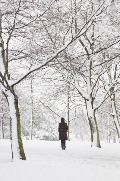Rear View of Woman Walking in Snowy Landscape