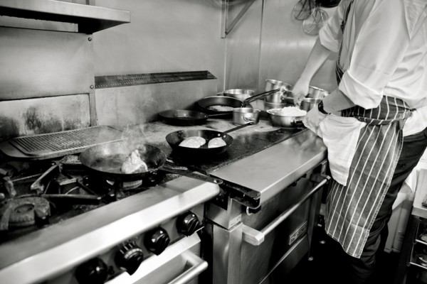 Chef putting Grated Cheese in Plastic Container