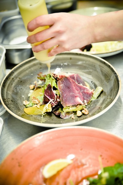 Chef drizzling Oil on Salad
