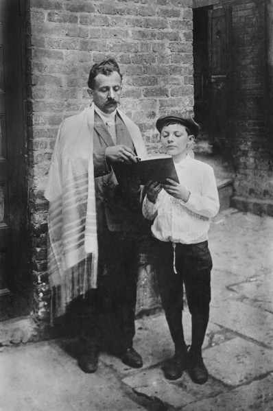 Rabbi and Boy reading Book while standing outside
