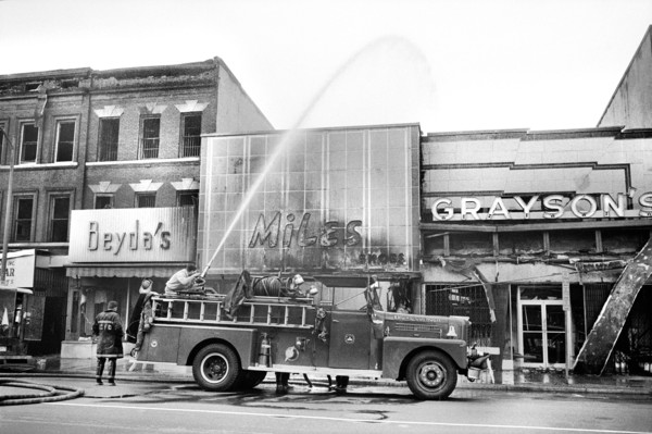 firefighters spraying water on shops that were burned during Riots that followed the Assassination of Martin Luther King, Jr., April 8