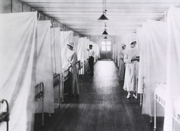 Nurses and Orderlies standing at foot of Beds separated by Sheets, Influenza Ward, 1918