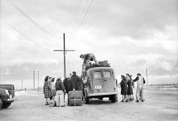 Man loading Bus with Luggage while Group of Japanese-American wait to leave Manzanar for Relocation