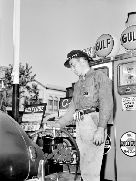 Gas Station attendant filling Gas Tank of Car