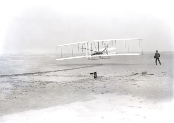 Wilbur Wright lying on machine