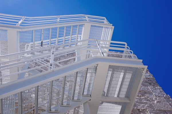 Low Angle View of White Fire Escape against Blue Sky