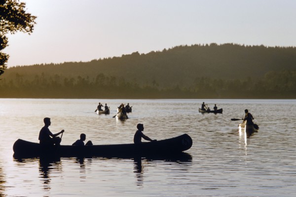 Silhouette of boys in Canoe Boats at Sunset