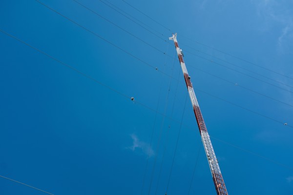 Low Angle View of Communications Tower with Guide Wires against Blue Sky