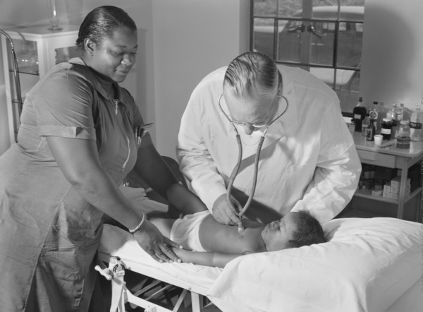 Dr. William J. Buck examining Child