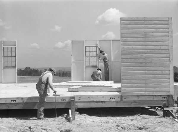 Construction workers building prefabricated houses for tenant farmers being relocated due to construction of Camp Croft