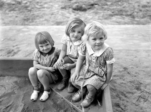Three children playing in sandbox