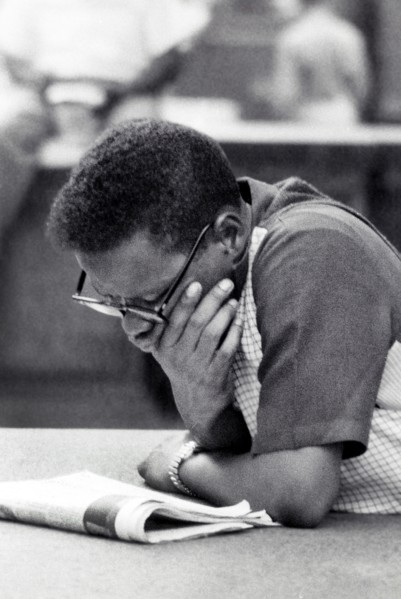 Half-length portrait of man reading newspaper
