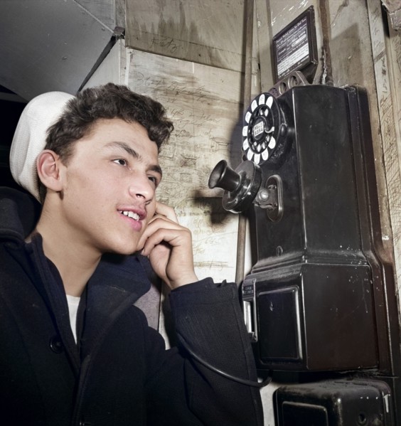 16-year-old teen boy who is in U.S. Naval Reserve talking on pay telephone, New York City, New