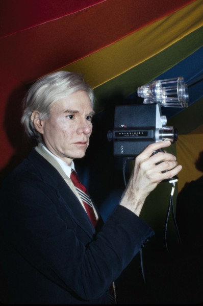 American pop artist Andy Warhol, half-length portrait holding Polaroid Polavision camera, Bernard