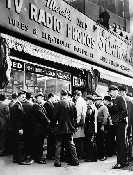 Crowd listening outside radio shop for news on President Kennedy, at Greenwich and Dey Streets, New