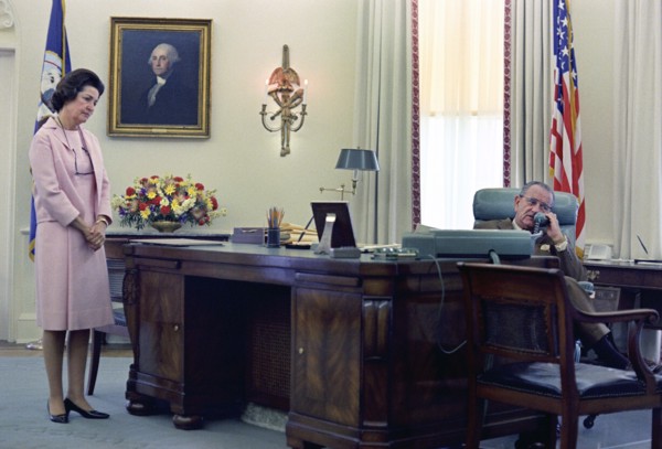 U.S. First Lady Claudia "Lady Bird" Johnson looking on as U.S. President Lyndon Johnson telephones