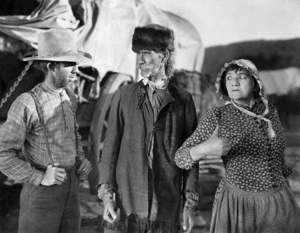 Tully Marshall (center), Louise Carver (right), on-set of the western film, "The Big Trail", Fox
