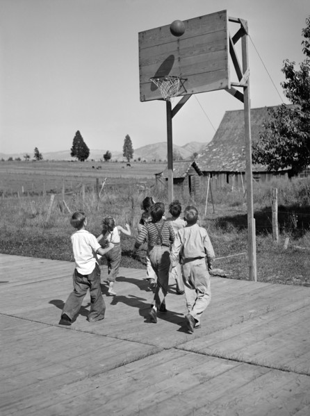 Group of children playing basketball at Farm Security Administration (FSA) mobile camp for