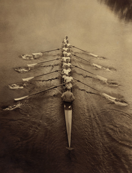 Eight rowers and coxswain rowing in sculling boat on river, Cambridge, England, UK, Bain News