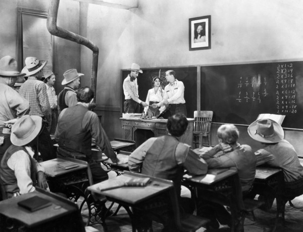 Lina Basquette (at desk, center), Hoot Gibson (at desk, right), on-set of the western film, "The