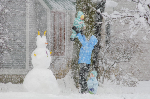 Mother playing with her two children in snow