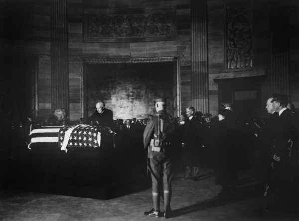 U.S. President Warren G. Harding placing wreath of flowers on casket of Unknown Soldier in rotunda