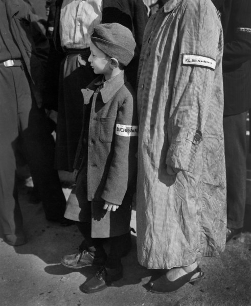 Six-year-old war orphan with Buchenwald badge on his sleeve waiting for his name to be called at