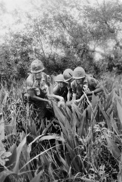 Members of Company B, 4th Battalion, 12th Infantry, 199th infantry Brigade, carrying wounded member