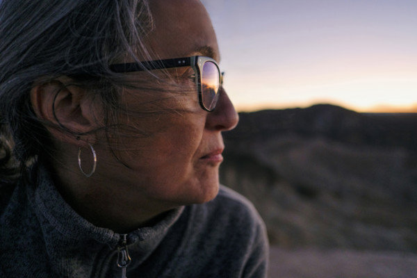 Head shoulders profile of senior adult woman looking at sunset, Zabriskie Point, Death Valley,