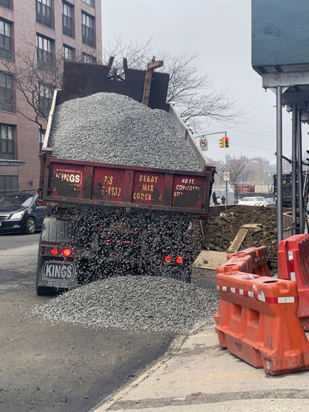 Dump truck delivering gravel on street, Brooklyn, New York, USA