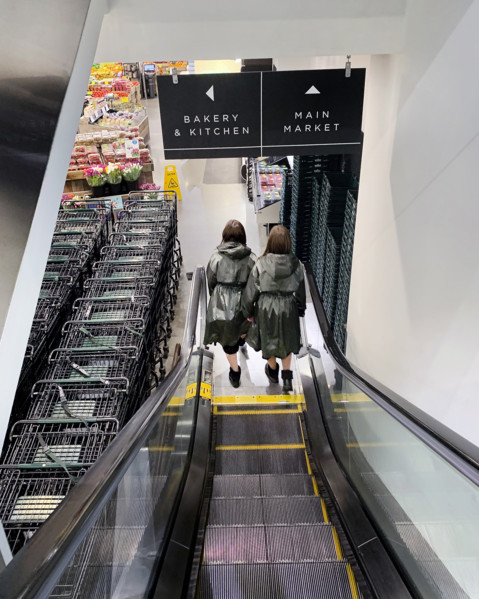 Rear view of two women descending escalator at supermarket, Brooklyn, New York, USA