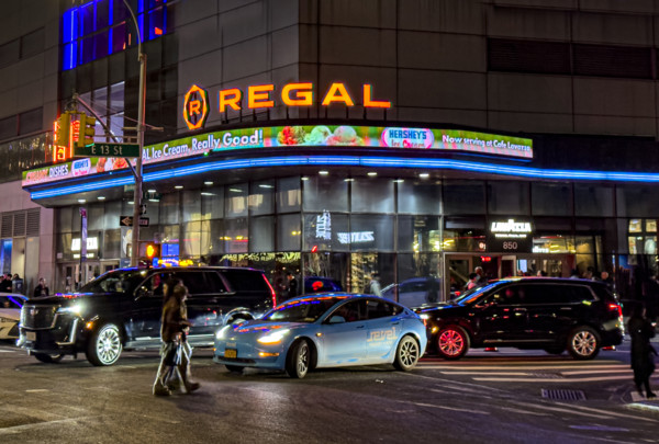 Regal movie theaters and street scene at night, New York City, New York, USA
