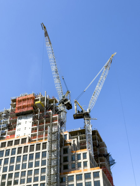 Construction cranes atop new residential building under construction, New York City, New York, USA