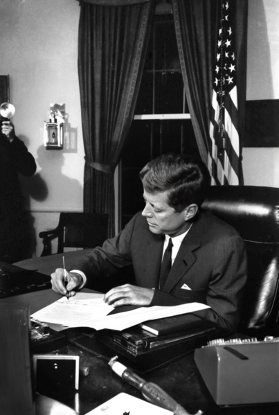 U.S. President John F. Kennedy signing the Interdiction of the Delivery of Offensive Weapons to