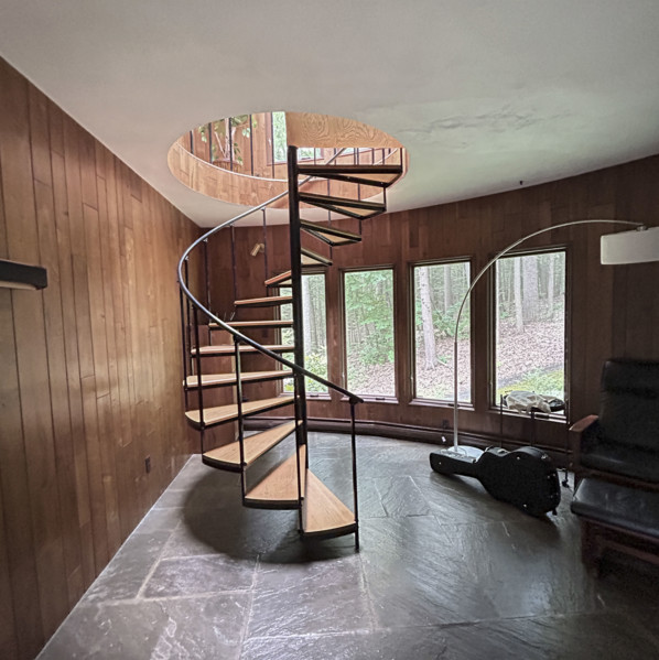 Spiral staircase in wood paneled room in residential home