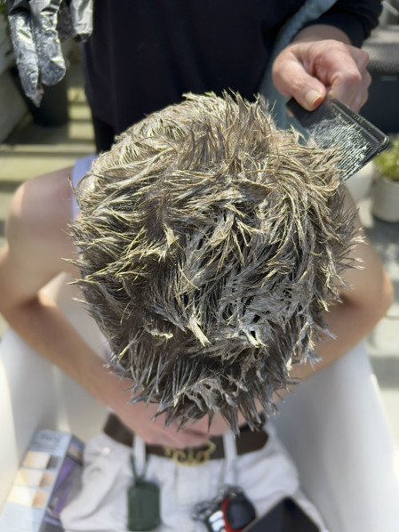 High angle view of young adult man getting his hair bleached