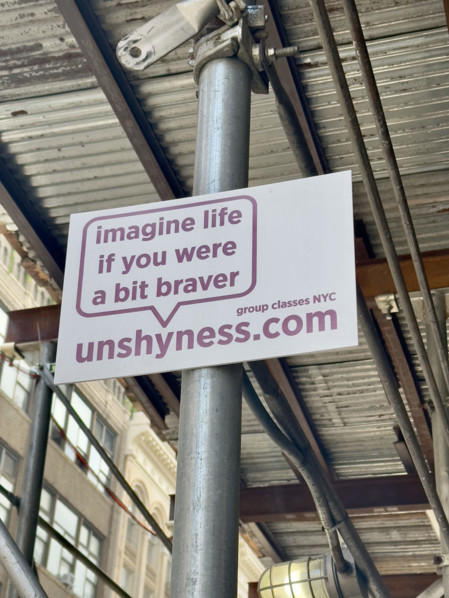 Advertising placard attached to building scaffold, New York City