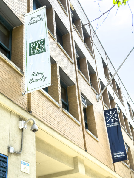 Banners hanging from building exterior for NYC lab School for Collaborative Studies and NYC Museum